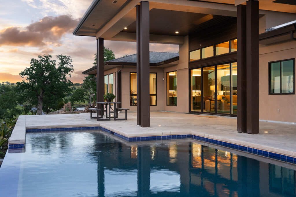 Modern home with infinity pool overlooking Northern California hills at sunset.