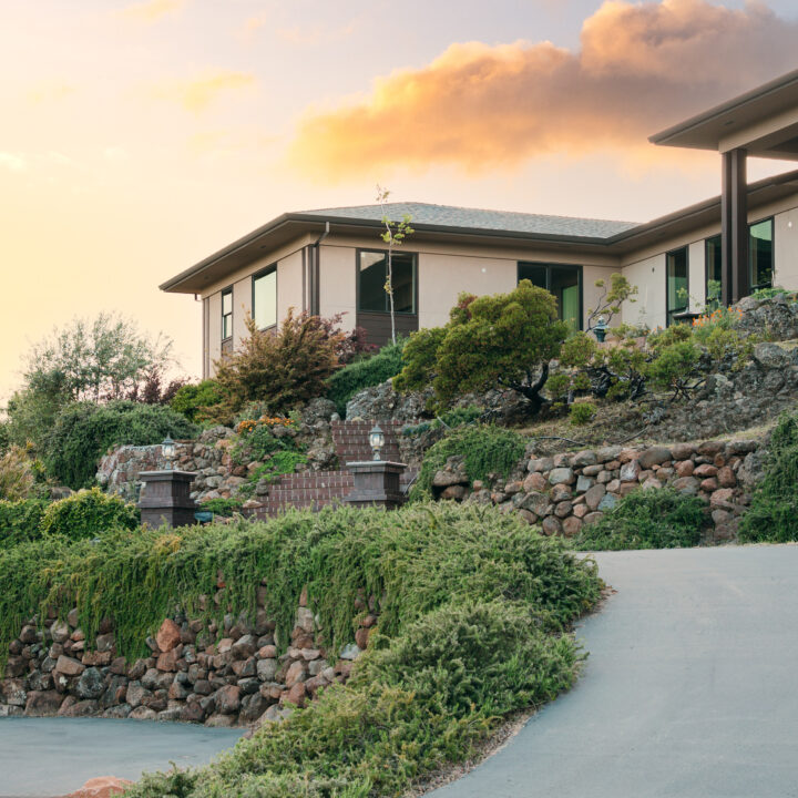 Contemporary home front entrance with stone walls, wood accents, and glass doors