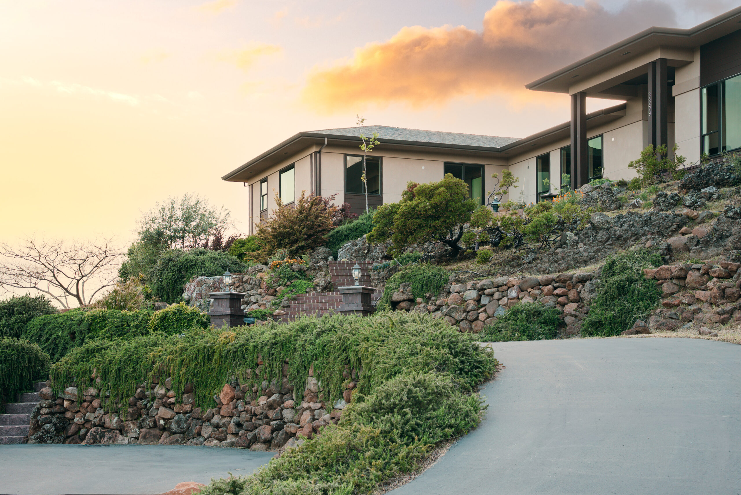 Contemporary home front entrance with stone walls, wood accents, and glass doors