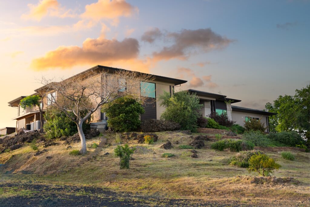 Side view of a modern Butte County home with large glass windows and sloped roofline.