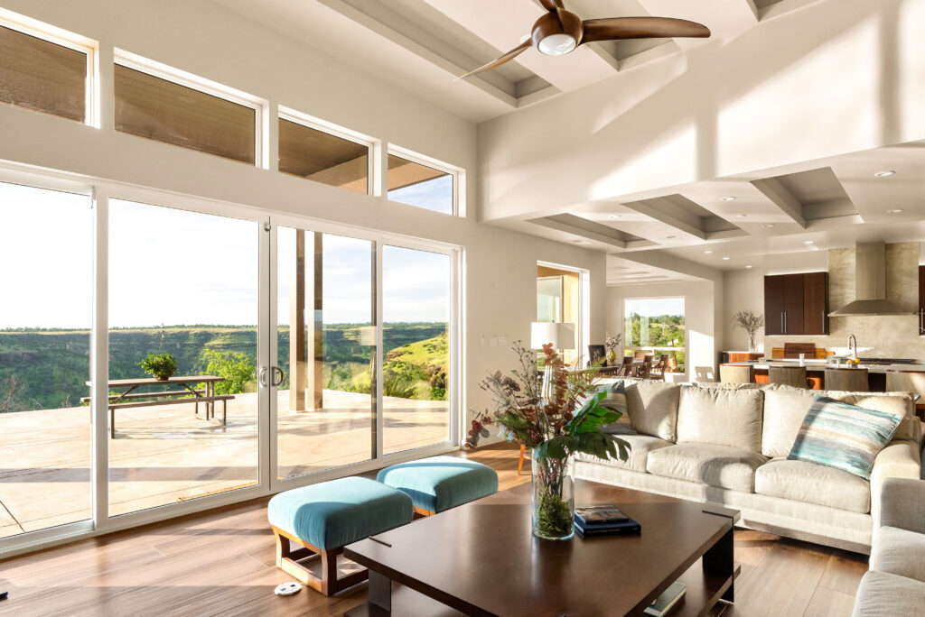 Modern living room with panoramic glass doors opening to California landscape