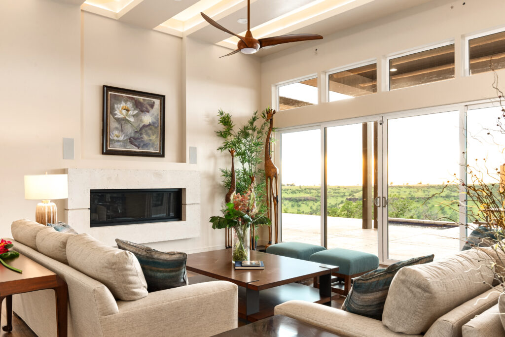 Modern living room with stone fireplace, neutral furniture, and natural light